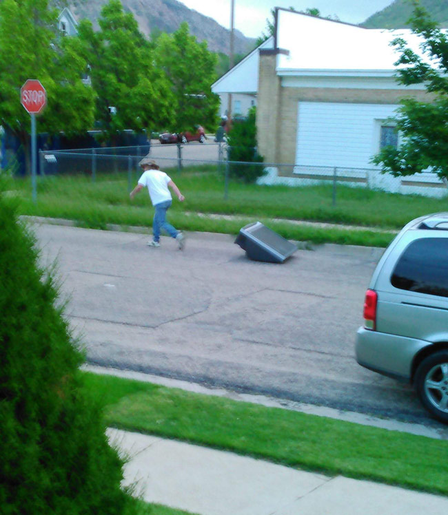 Man dragging TV down the street.