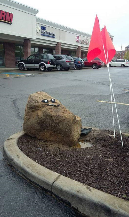 Someone put a face on the notorious rock that people are constantly hitting