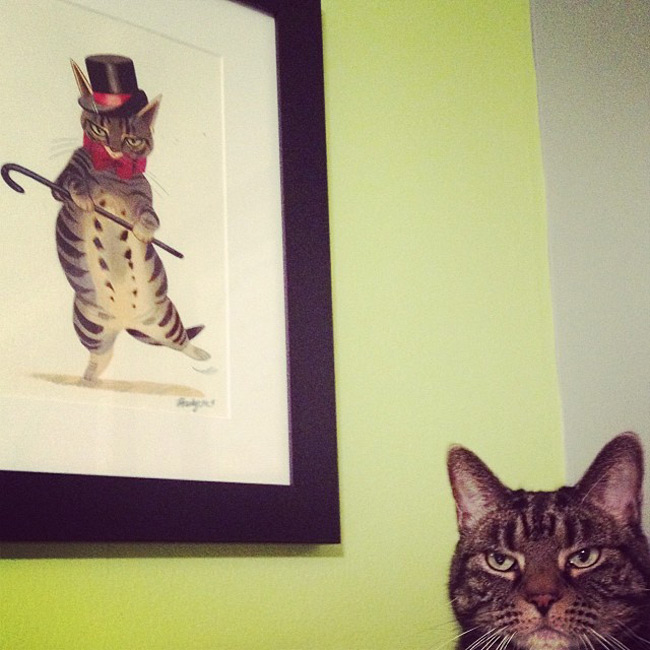 A photo of a cat next to the painting I made of him!