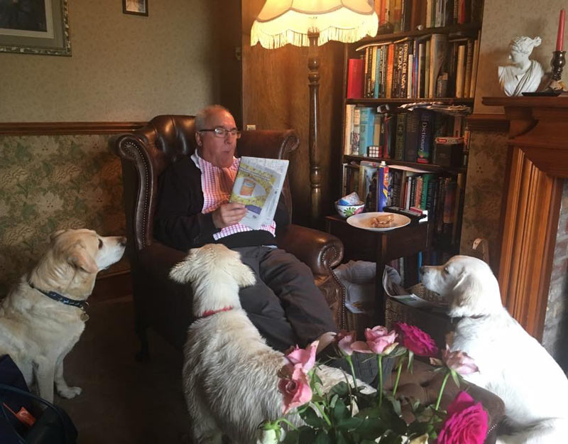 My dad reading the paper to the dogs
