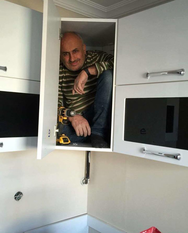 Contractor gets in the cabinet he just built to prove its sturdiness