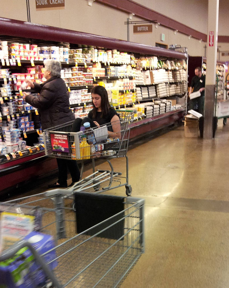 Just a grown adult riding in a shopping cart while her mother shops