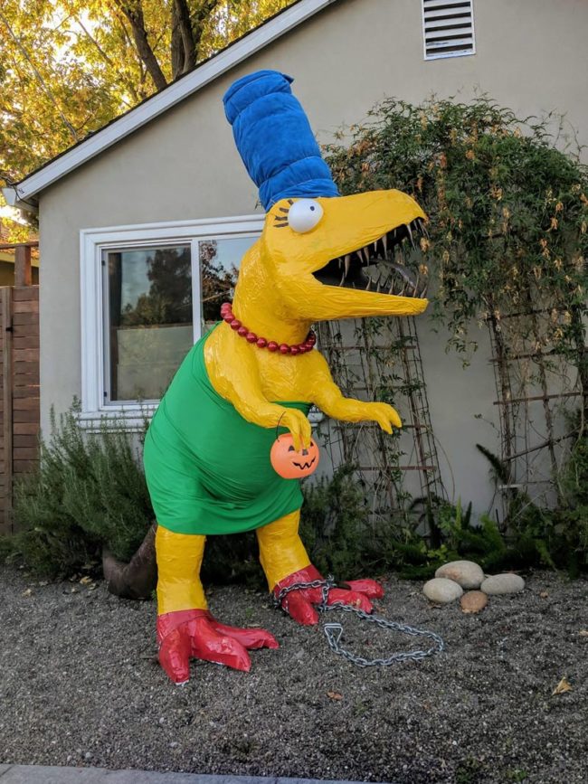 A house in our city always dresses up their dino statue for Halloween. This year takes the cake