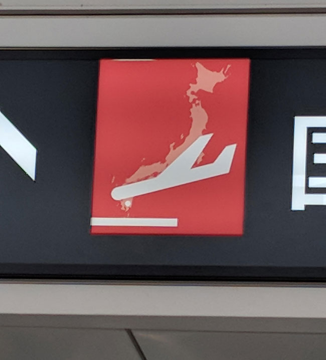 The outline of Japan on the sign makes it look like the plane is crashing in a ball of flames