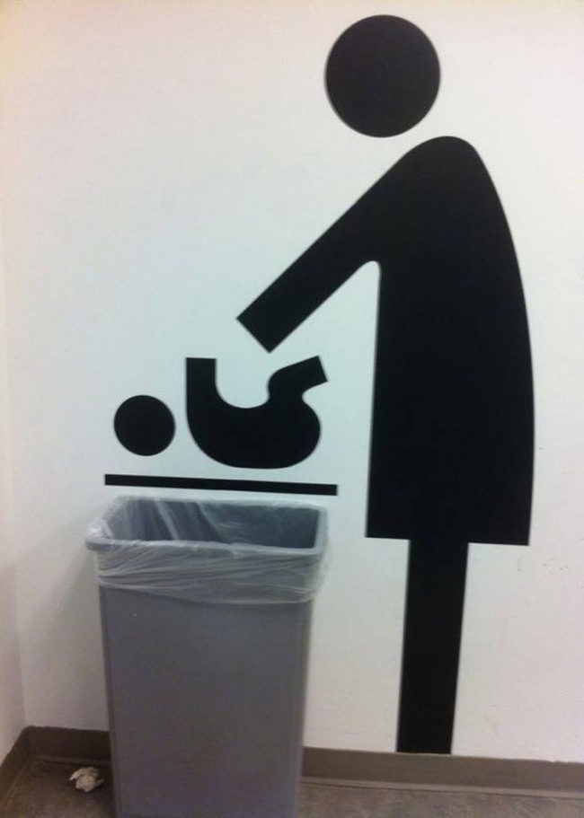 The placement of the trash can and baby changing sign