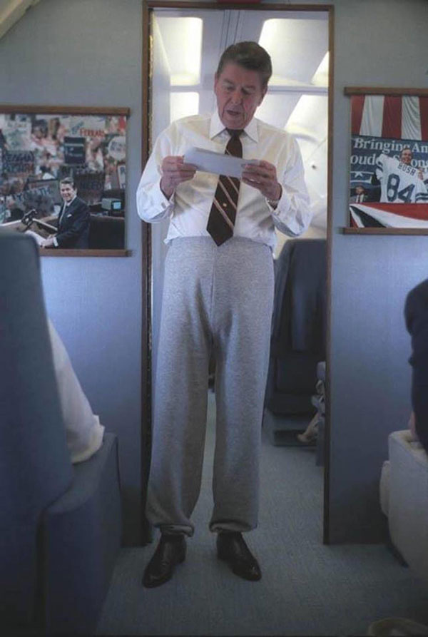 Ronald Reagan wearing sweatpants talking to staff aboard Air Force One on a trip to Iowa, September 1984