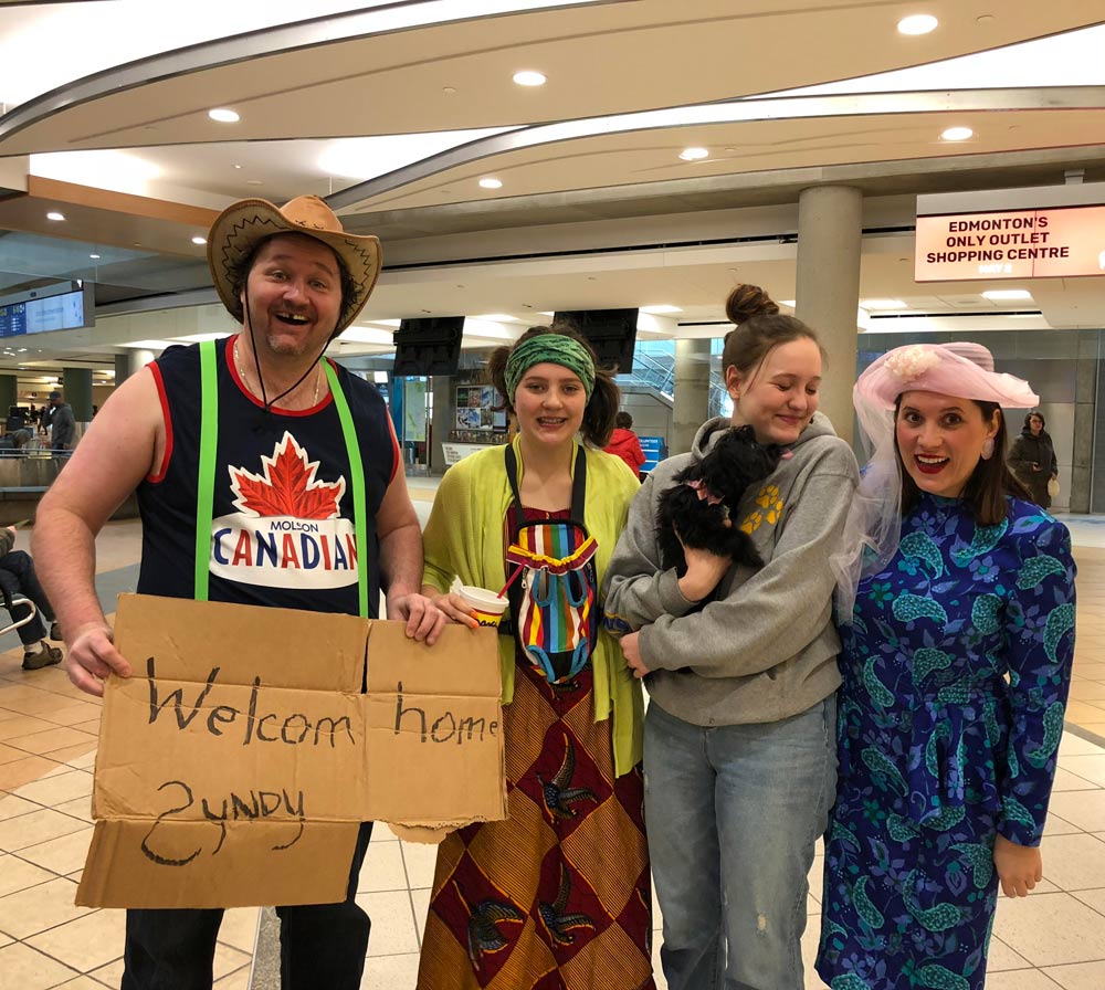 We decided to embarrass our daughter at the airport after 3 months away. (we don't normally dress this way)