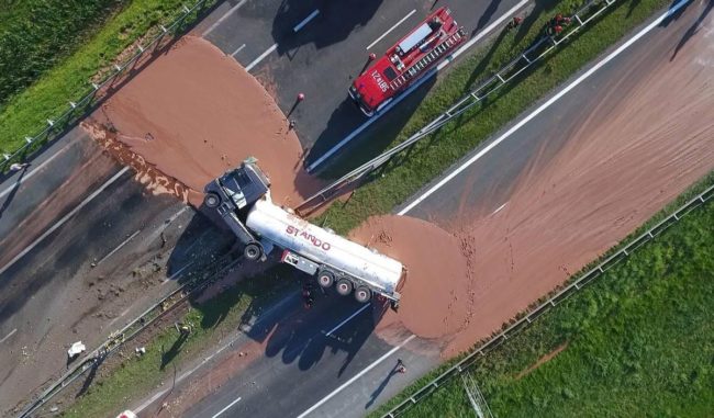 A truck lies overturned on the Polish highway having spilled over 12 tons of liquid chocolate on the road