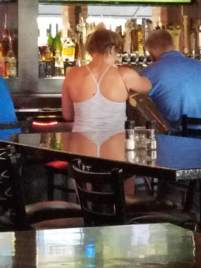The reflection of her tank top on the table