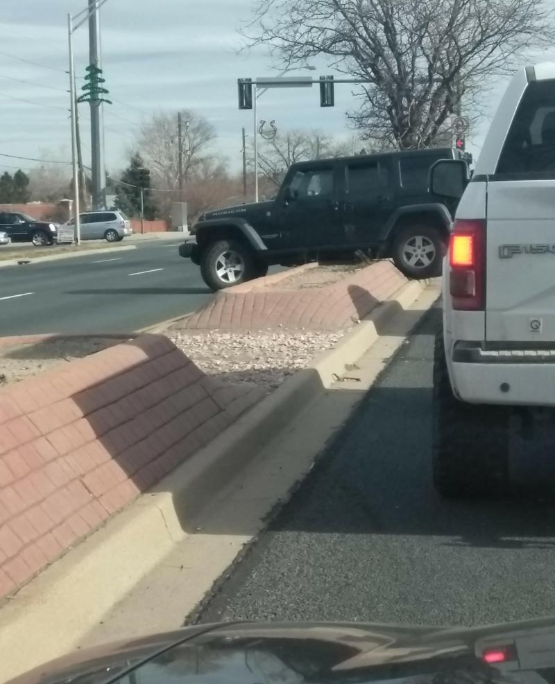 This guy got his JEEP stuck while trying to cross the median at a red light...