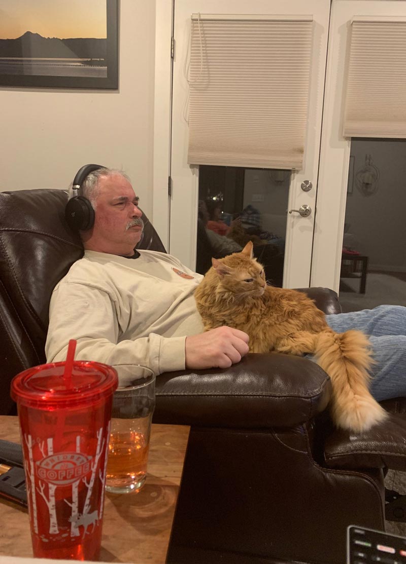 My dad and his cat angrily watching TV