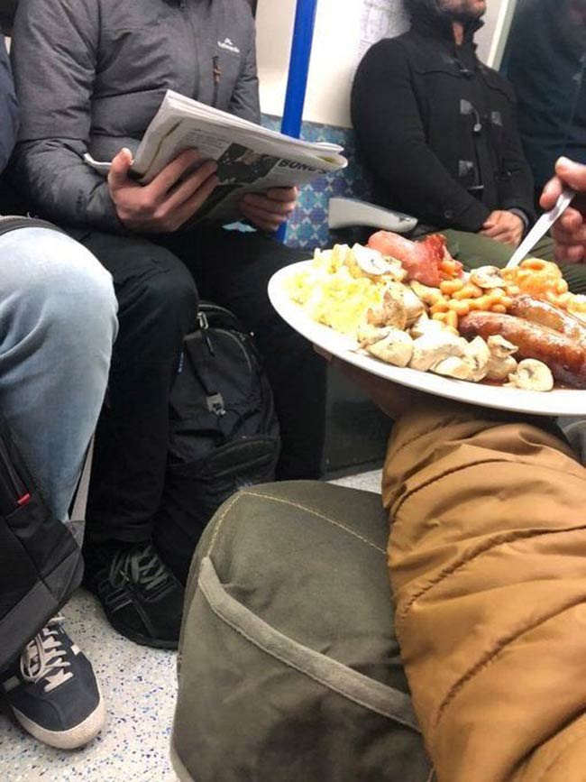 A bloke tucking into a full English breakfast on the tube