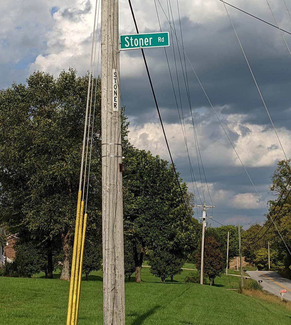 This street sign has been stolen a countless number of times. It keeps getting higher, literally.