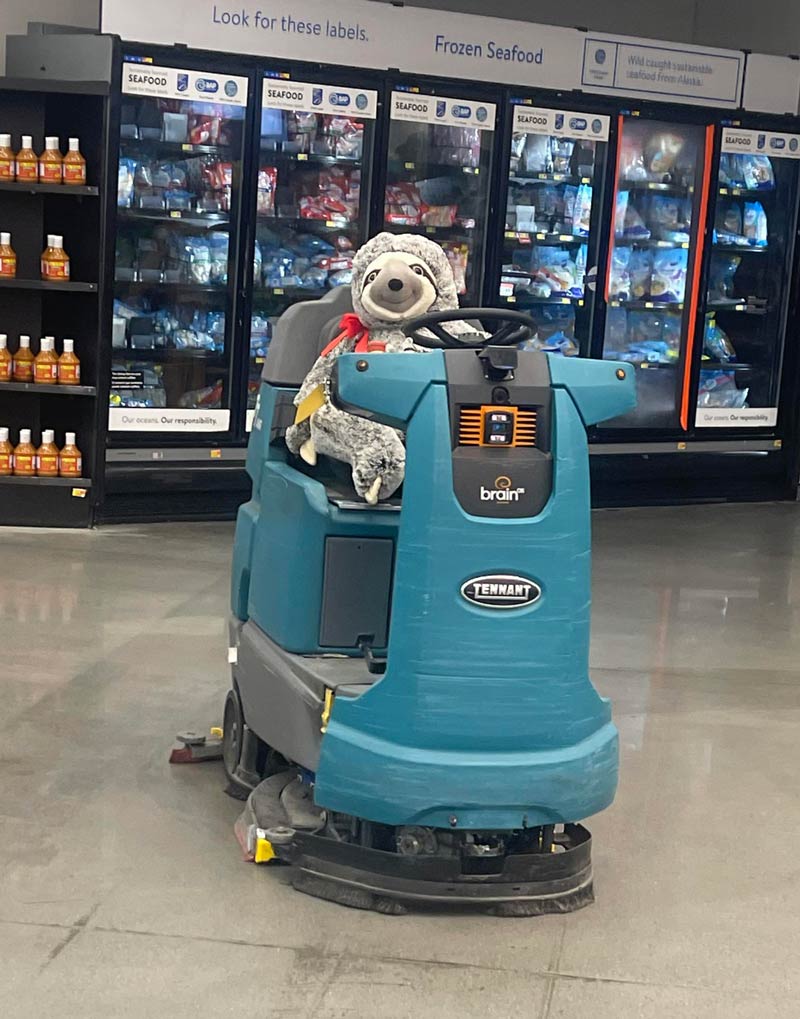 A stuffed sloth waxing the floors at Walmart