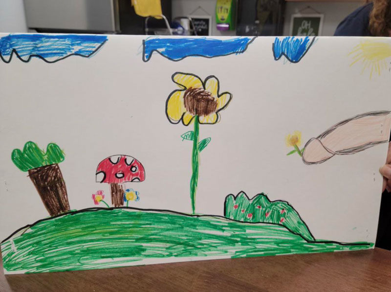 My friend's mom is a teacher and her student drew this.. His hand picking a flower in the meadow