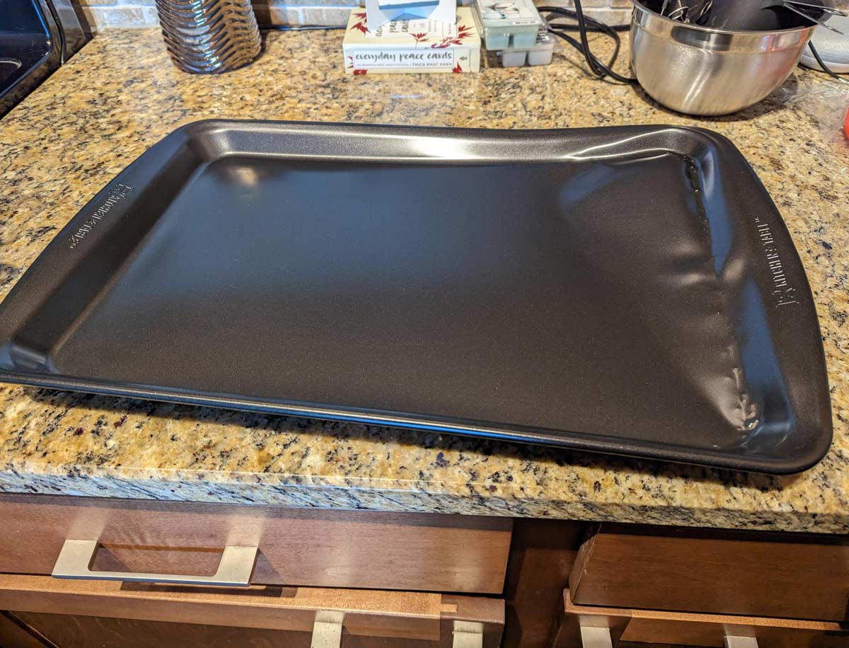 I bought this cookie sheet last night. In the parking lot it slid out of my shopping cart and immediately got run over by a Jeep