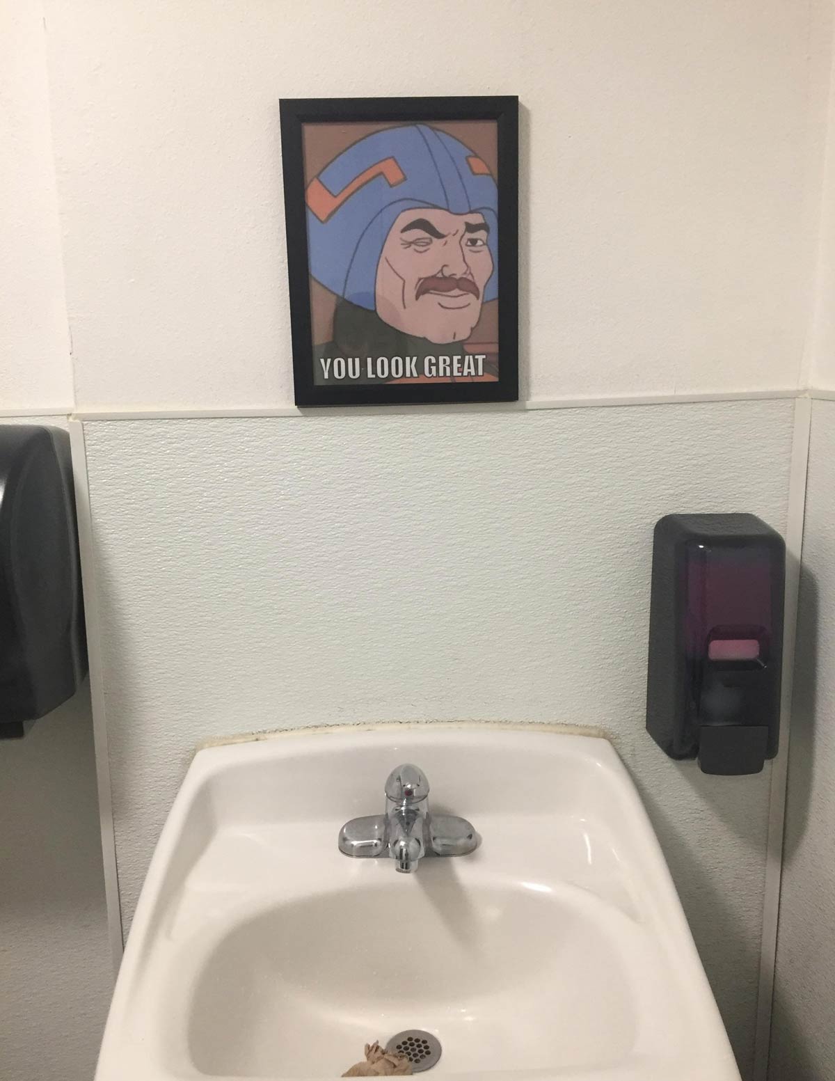 This bathroom that has an encouraging picture instead of a mirror