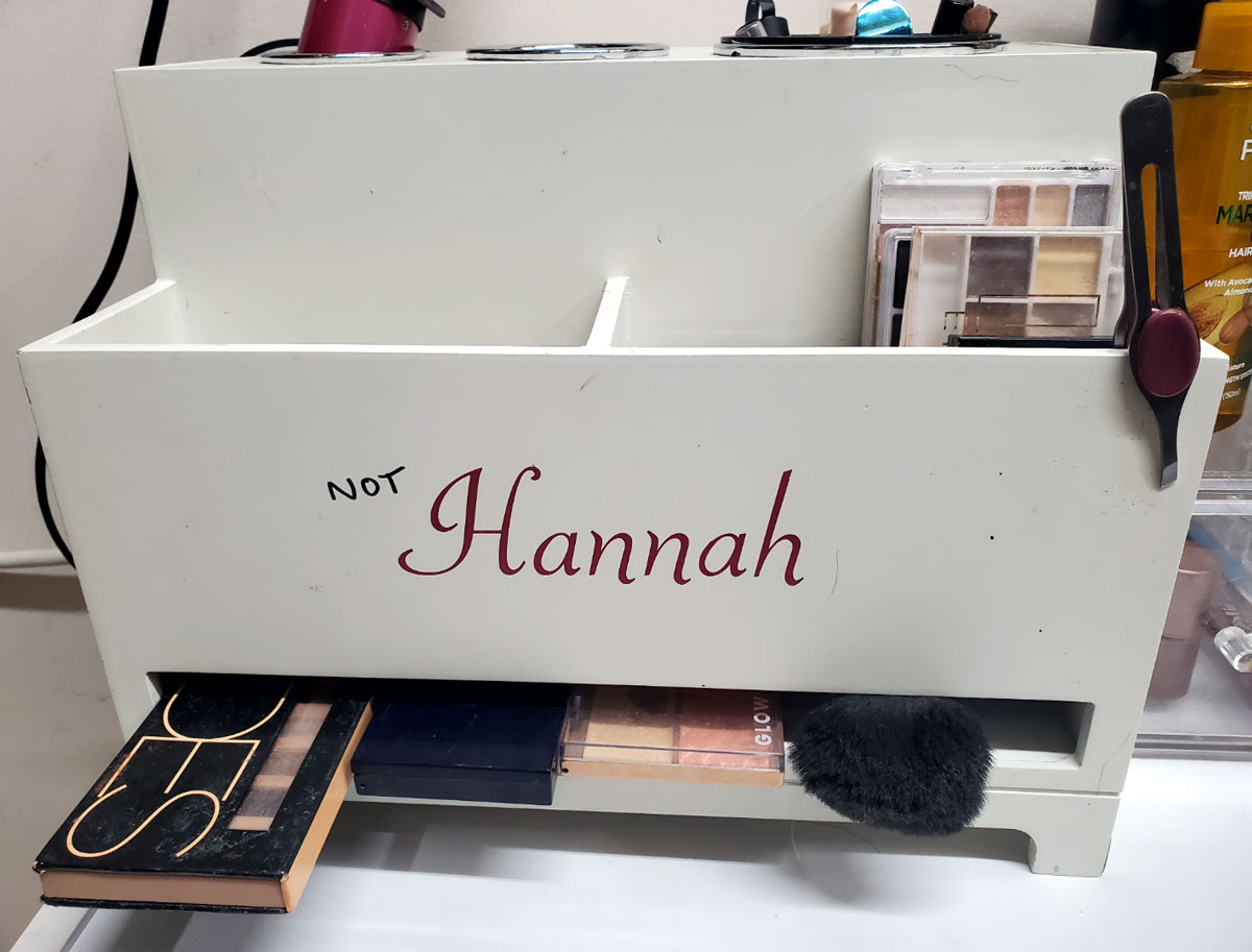 I bought this makeup holder from a thrift store. My name is not Hannah. I asked my husband if he could get creative and cut out new vinyl or somehow cover up the name. This was his million dollar idea
