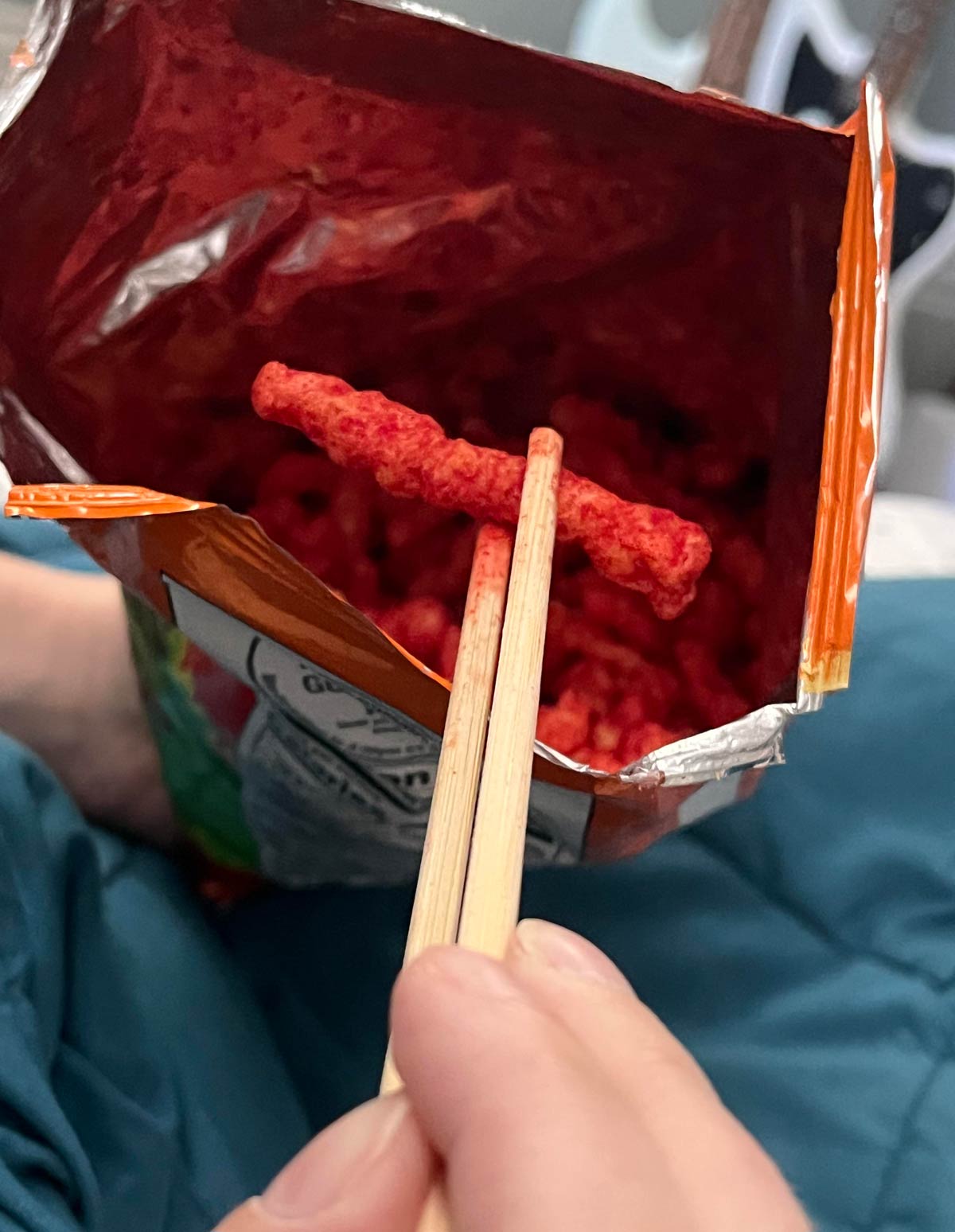 My girlfriend uses chopsticks to eat her Hot Cheetos