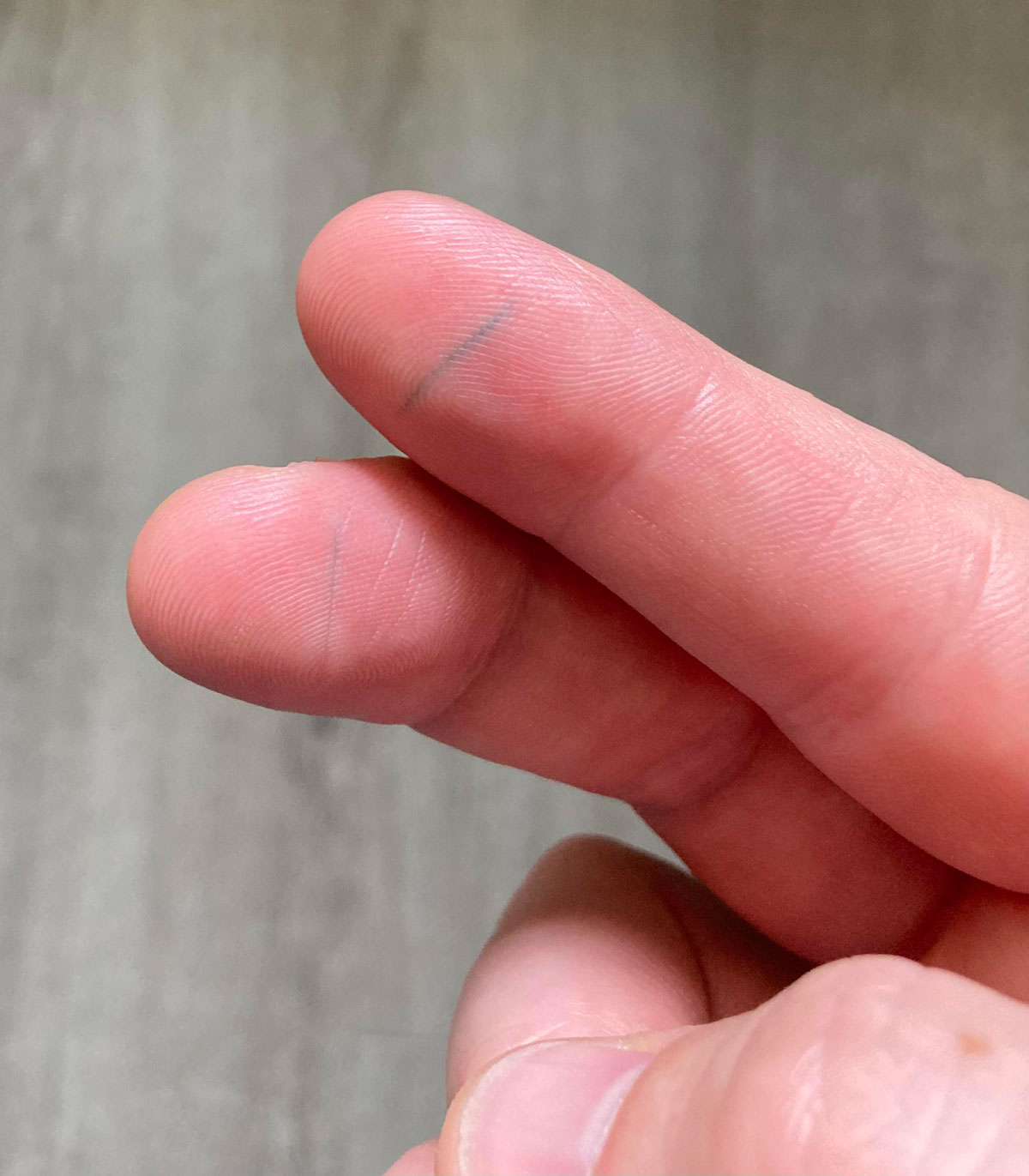 Accidental Tattoo - I cut my fingers when cleaning out a can that had some ash in it. When it healed, the ash stayed and created a tattoo on 2 of my fingers