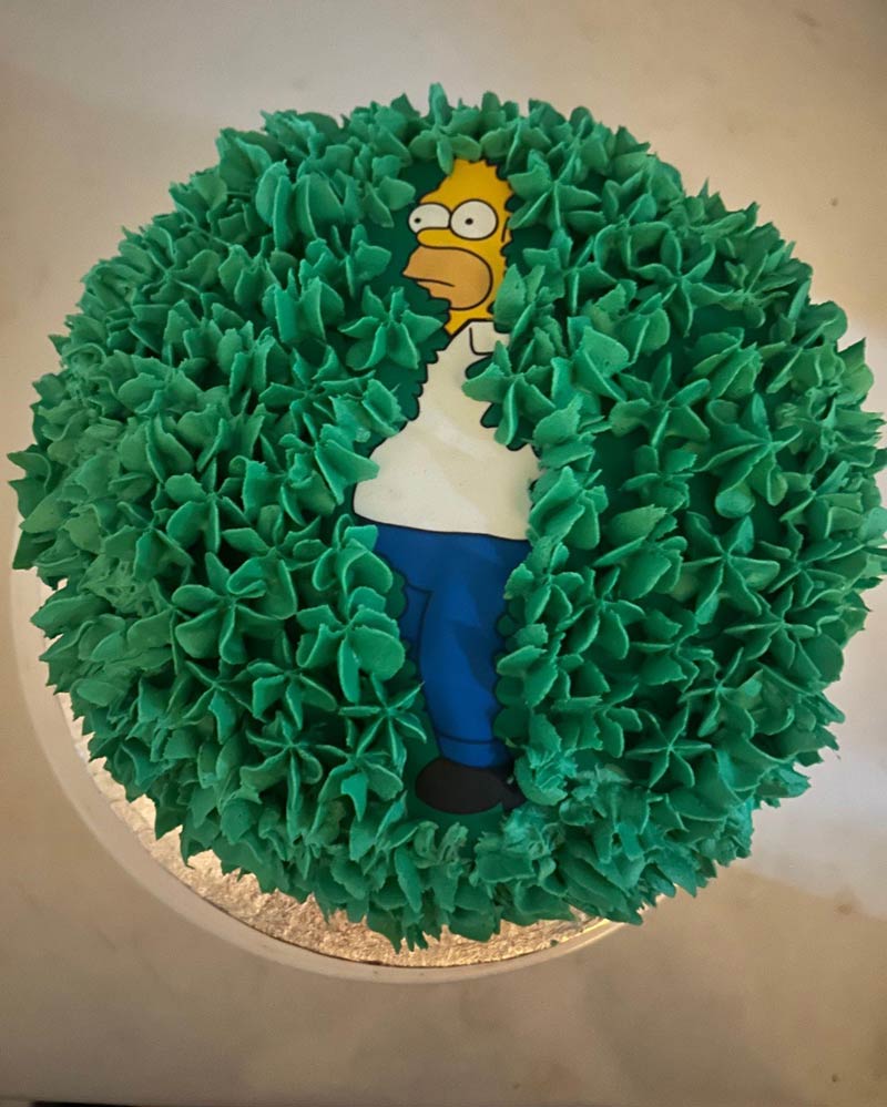 Homer Simpson disappearing into a hedge cake