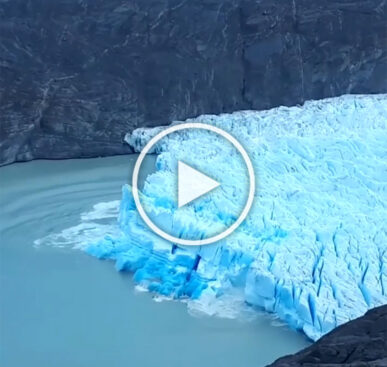 Iceberg flipping over revealing very old blue ice