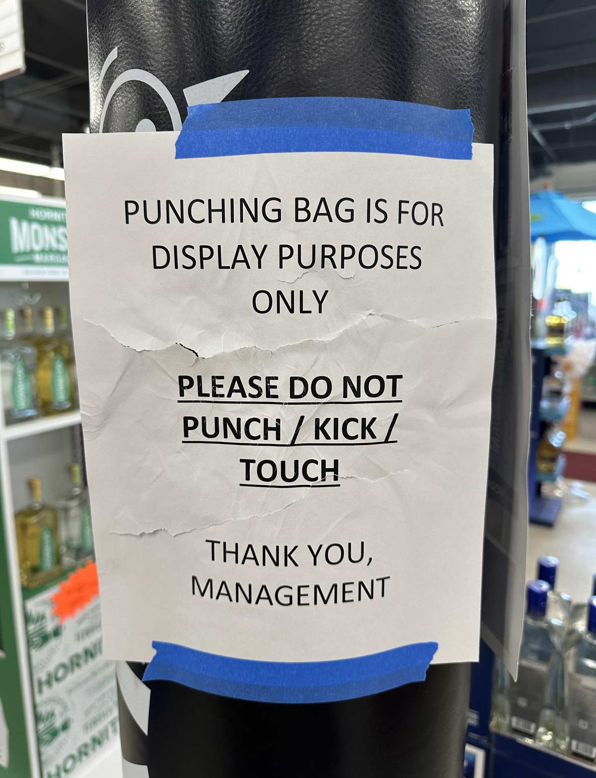 The beat up sign on this punching bag display at the liquor store I manage